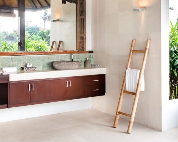 浴室有木橱柜，植物和一个石头独立浴缸