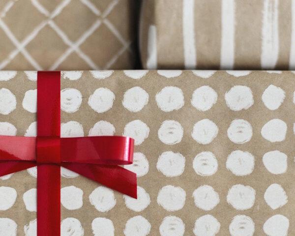 礼物用棕色和白色的纸包着，上面有红色的蝴蝶结