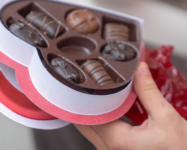 一只手拿着一盒心形巧克力