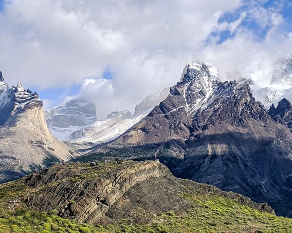 智利的一座山脉，背景是云，前景是绿色的山丘