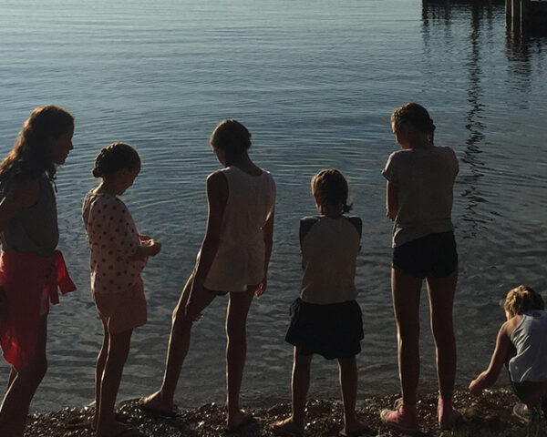 一排在湖边玩耍的孩子