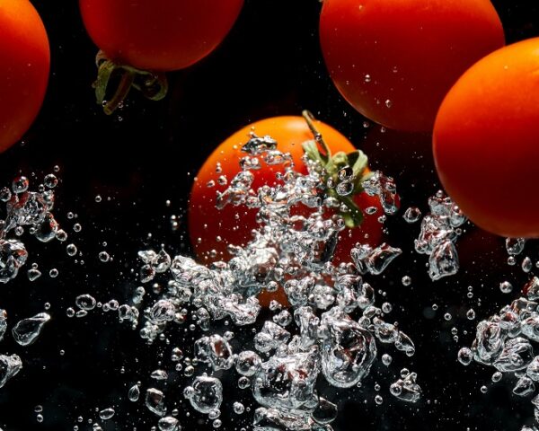 西红柿漂浮在水中，下面有气泡流