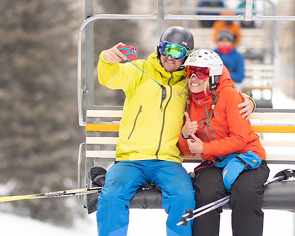 两个人手挽着手在滑雪缆车上自拍